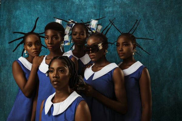 A group of 6 black women potrait style in blue school uniform with varying African hair styles